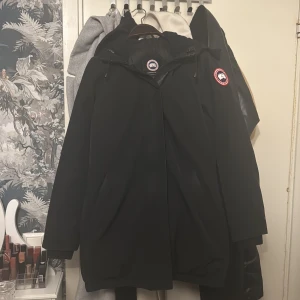 Svart parkajacka från Canada Goose  - Säljer en svart parkajacka från Canada Goose med huva och dragkedja. Jackan har långa ärmar och en klassisk design med logotyp på ärmen. Perfekt för kyliga dagar. Köptes från en säljare här för 3 år sen och är i användt skick därav priset är lågt. Pälsen ingår självklart med jackan. Deffekterna går att fixa för ett minimalt pris dock har jag ingen användning av den längre :) priset kan diskuteras 