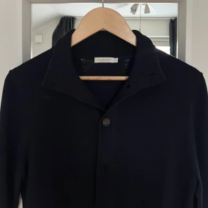 Cardigan Suitsupply - Snygg navyblå kofta från Suitsupply med knappar hela vägen fram. Klassisk och stilren design som passar till det mesta.