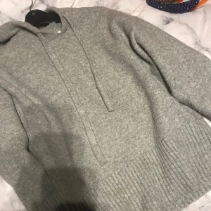 Grå hoodie från Zara - Mysig grå hoodie från Zara i mjukt material. Perfekt för kyliga dagar med sin bekväma passform och ribbade detaljer vid ärmslut och nederkant. Har en klassisk huva med dragsko.