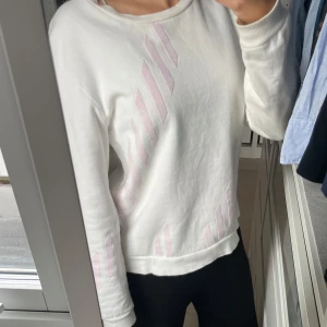 Vit tröja med rosa detaljer.  - En fin mysig tröja nu till hösten. Super mjuk inuti. Har bara använt tröjan några få gånger. Säljer den eftersom den inte kommer till användning alls längre. 
