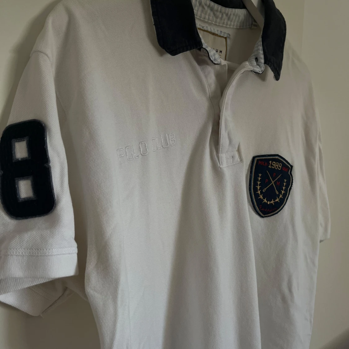 Vit pikétröja med broderad logga - 91