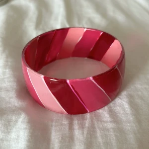 Rosa armband - En rosa bangle med randigt mönster, super trendig just nu, köpt på ibiza år 2000-2005 🌟🩷