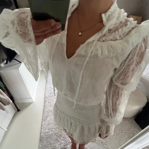 Vit spetsklänning med volanger - Säljer en superfin vit spetsklänning med volanger. Klänningen har långa ärmar och en v-ringad hals. Den är helt oanvänd med lappen kvar💕💕(nypris 617kr) slutsåld på hemsidan. Sista bilden är lånad från Pinterest! 