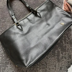 Us Polo assn handväska - Us. Polo assn handväska, fungerande drag kedja, fint skick förutom ett slitet hörn, syns inte vid andvändning, inte mina bilder!! Passar A4 Inte fast pris  Skilda föräldrar så kan ta någon dag att skicka den