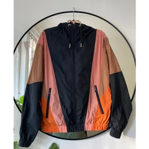 Flerfärgad vindjacka lindex - Säljer denna supersnygga vindjacka från Lindex i stl XS. Den är svart med rosa, ljusbruna och orange detaljer, och har en luva. Fint skick. Perfekt inför hösten!🍁 skriv om du har frågor✨