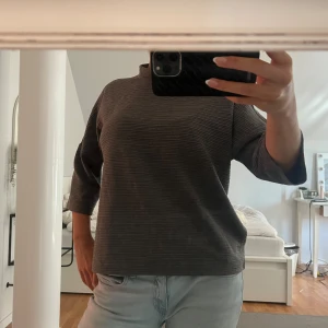 Grå ribbad tröja - Säljer en snygg grå ribbad tröja i storlek M. Tröjan har trekvartsärmar och en liten polo. Perfekt för höst och vinter! Den är i bra skick och passar både till vardags och lite finare tillfällen. Superbekväm och stilren! 💖