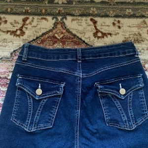 Low bootcut jeans med knappar på backfickan  - Jätte fina bootcut jeans med knappar på backfickan. Har använd byxorna  länge då dem har varit en favorit hos mig därmed är nere delen vid foten lite slitna (swipa för bilden)