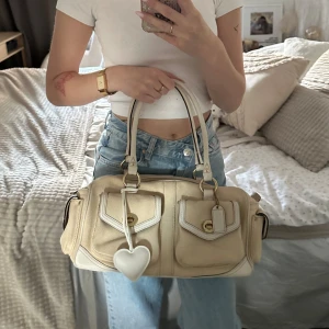 Coach Hampton Suede Väska - Säljer en väldigt sällsynt handväska från Coach. Den har en identifieringskod som godkänner att denna är äkta. Trots sin ålder så är den i väldigt fin skick. Kan ha små skavanker på kanterna men inga fläckar eller repor på lädern! Lycka Till ✨