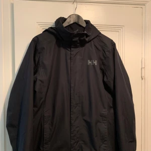 Helly Hansen jacka  - Svart HH regular normal jacka med huva och dragkedja framtill. I gott skick, storlek M.