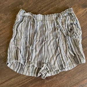 Randiga shorts - Randiga shorts i vitt och grått gjorda i viskos med knytband i midjan. Ganska höga i midjan, men går och vika ner. Väldigt sköna att ha på sig både till vardags, men även att sova i. 