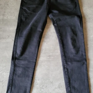 Svarta jeans från Replay - Säljer ett par svarta jeans från Replay i modellen Hyperflex. De är i nyskick och har en slim passform. Jeansen är tillverkade i ett stretchigt material som gör dem bekväma att bära hela dagen. Perfekta för både vardag och fest!