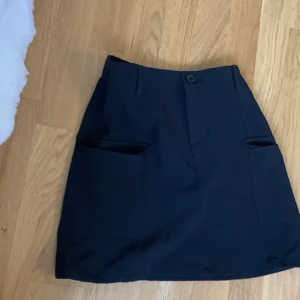 Svart fin Kjol - Svart fin kjol med många fickor och i bra skick