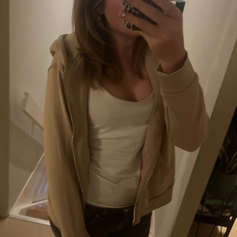 Säljer en beige hoodie från H&M i storlek S. Den är supermjuk och bekväm, perfekt för vardagsbruk. Hoodien har en dragkedja framtill och en skön huva. Använd några gånger men i bra skick. Perfekt för höst och vår!. Hoodies.