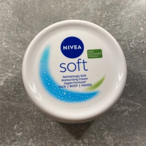 Nivea Soft Moisturizing Cream - Säljer en Nivea Soft Moisturizing Cream som är perfekt för ansikte, kropp och händer. Denna kräm är vegansk och har en uppfriskande mjuk formula som ger 48 timmars återfuktning. Den absorberas snabbt och är inte fet. Innehåller vitamin E och 100% naturlig jojobaolja. Perfekt för att hålla huden mjuk och återfuktad!