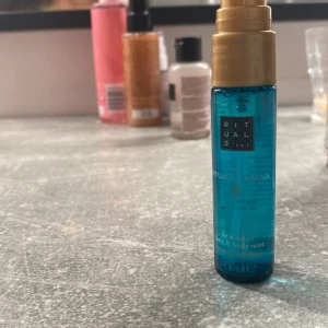 Blå kroppsmist från Rituals - Säljer en fräsch och uppfriskande kroppsmist från Rituals. Den är blå och kommer i en liten, smidig flaska som är perfekt att ha med sig i väskan. Doften är del av deras 'Ritual of Karma' serie och ger en härlig känsla av lugn och välbefinnande. Perfekt för att fräscha upp sig under dagen! 💙