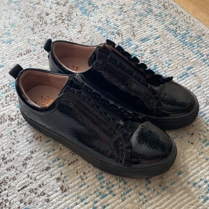 Svarta finskor - Svarta finskor med lack och volang 