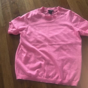 Rosa kortärmad tröja från Lindex - Säljer en söt rosa kortärmad tröja från Lindex. Perfekt för vår och sommar med sin mjuka och bekväma passform. Tröjan har en rund halsringning och är tillverkad i ett lätt material som gör den skön att bära. Passar perfekt till jeans eller kjol! 🌸