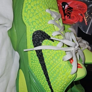 Gröna Nike sneakers med svart Swoosh - Snygga gröna Nike sneakers med en svart Swoosh och vita snören. Skorna har en unik textur på ovansidan och röda detaljer på plösen. Perfekta för den som vill sticka ut, det är inomhus skor som är aldrig använda eftersom jag blev skadad 1 vecka efter jag fick de och kunde inte spela mer. 