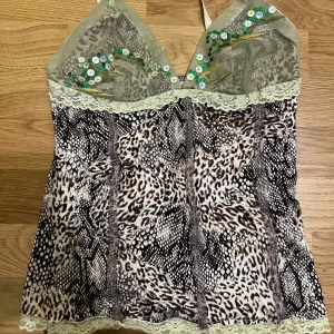 Leopardmönstrad topp med paljetter - Snygg leopardmönstrad topp med spetsdetaljer och gröna paljetter. Toppen har justerbara axelband.