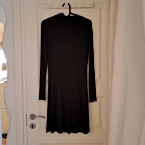 Svart ribbad klänning från Vila - Snygg svart ribbad klänning från Vila i storlek S. Klänningen har en enkel och stilren design med långa ärmar och en normal passform. Perfekt för en chic och minimalistisk look.