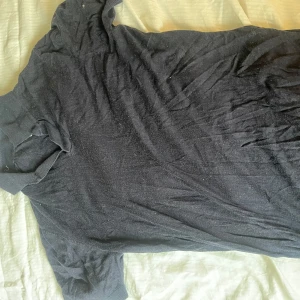 Svart t-shirt från A Day's March - Säljer en svart t-shirt från A Day's March. Den har en enkel design med korta ärmar och en rund halsringning. Perfekt för en avslappnad stil eller kanske en sommarkväll