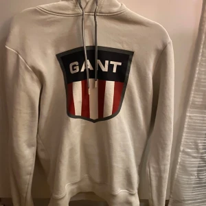Vit och grå hoodie från GANT - Tre olika tröjor av känt märke i olika färger och storlekar. Det är det gamla märket på alla tröjorna.  Bild 1-2: vit hoodie i stl. S herr. Använd ett fåtal gånger och är i fint skick. Normal i storlek. 350 kronor för bara den.   Bild 3-5: grå hoodie i stl. S herr. Ganska flitigt använd och på femte bilden kan ni se att märket är lite utslitet men annars i fint skick. 250 kronor. Paketpris: 500 kronor Finns att hämta i Hudiksvall, djur finns i hemmet. Betalas med swish.😊 