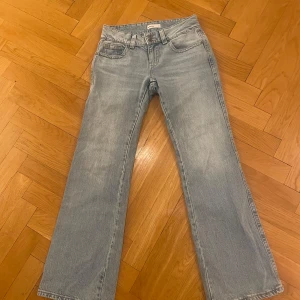 Ljusblå jeansbyxor från Gina Tricot  - Ljusblå bootcut med knappfickor bak 
