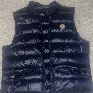 Marinblå moncler väst - Använd ett fåtal gånger storlek 2/m dem är lite små i storlekar så rekommenderar någon med en lite mindre storlek, väldigt bra skick, säljs pga att den inte passar. Pris kan diskuteras