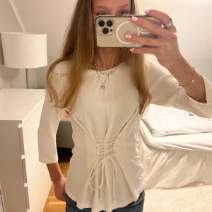 Vit topp med snörning - Säljer denna coola toppen från Sthlm LM😍😍Så snygg både till skolan och fest! 