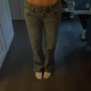 Blå jeans med bootcut - Snygga blå jeans med bootcut-stil och låg midja. Perfekta för en avslappnad look. Klassisk design med fem fickor och knappgylf.