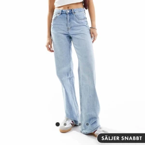 Ljusblå jeans från Stradivarius - Snygga ljusblå jeans från Stradivarius med medelhög midja och en avslappnad wide fit. Perfekta för en trendig look. Klassisk femficksdesign och knappgylf.