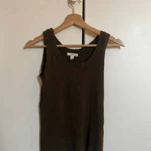  linnetopp från H&M -  olivgrön ribbad linnetopp från H&M.