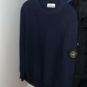 Mörkblå stickad tröja från Stone Island - Säljer en snygg mörkblå stickad tröja från Stone Island. Tröjan har en rund halsringning och den ikoniska logotypen på ärmen. Perfekt för kyligare dagar och ger en stilren look. i princip helt ny pris kan diskuteras 
