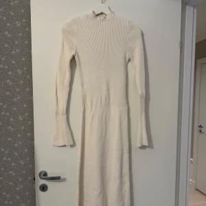 Vit ribbad midiklänning - Säljer en  vit ribbad klänning med vida ärmar. Använd en gång så nyskick. 