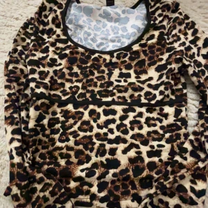 Leopardmönstrad långärmad tröja - Snygg leopardmönstrad långärmad tröja med rund halsringning. Perfekt för att lägga till lite djurmönster i garderoben. Tröjan har en stilren design och är gjord i ett mjukt material för extra komfort.