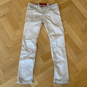 Vita jeans från Jacob Cohen - Snygga vita jeans från Jacob Cohen med klassisk design. De har en midwaist passform och är tillverkade i ett mjukt bomullsmaterial. Perfekta för en stilren look med knappdetaljer och broderad logga.