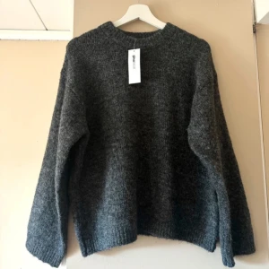 Mörkgrå stickad tröja  - Säljer en mysig mörkgrå stickad tröja från Gina. Inte alls använd! 