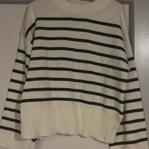Randig stickad tröja i offwhite och svart - Säljer en super fin randig stickad tröja i offwhite med svarta ränder. Tröjan har en oversized passform. Helt ny med lapp kvar. Storlek M💕