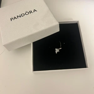 Silverörhänge med palm från Pandora -  Från Pandora, en charmig palmberlock. Perfekt för att ge en touch av tropisk stil till din look. Kommer i originalförpackning.