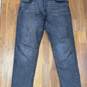 Jack Jones jeans - Gråa tapered fit jeans från Jack & Jones (Mike modellen), storlek 32/30. Mycket bra skick på dom, inga tecken på användning. Kontakta mig vid frågor!