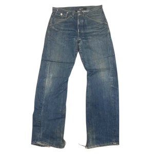 Blå jeans från Levi's - Snygga blå jeans från Levi's med riktigt feta bakfickor och knappgylf. Riktigt fin wash men har en del slitage vid benöppningen och har haft ett tidigare hål vid ena bakfickan som har blivit lagat hos en skräddare. 