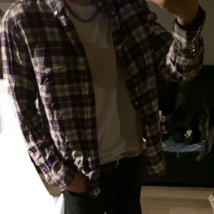 Flanellskjorta  - Lila, vit flanellskjorta som inte används längre. Den är i fint skick. Hör gärna av dig vid intresse!😁