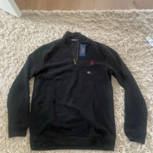 Svart Ralph Lauren Half Zip Tröja - svart tröja med halv dragkedja från ralph lauren, storleken är medium och passar 180 cm man