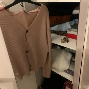 Beige kofta med knappar - Mysig beige kofta i ribbat material med v-ringning och knappar framtill. Perfekt för kyliga höst- och vinterdagar. Passar både till vardags och lite finare tillfällen. 🧥✨