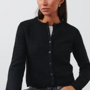 Stickad kofta - Säljer en fin svart kofta med knappar framtill. Perfekt för både vardag och fest. Den är långärmad och gjord i ett mjukt material.‼️Priset kan diskuteras vid snabb affär‼️ Hör av dig vid egna bilder🫶🏻🥰