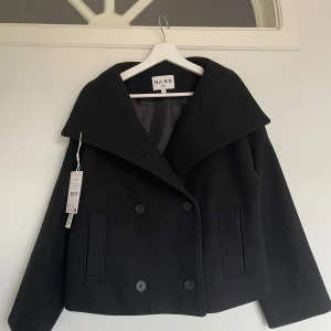 Svart kappa - Jättefin höst kappa från NA-KD. Köpt på Plick för 1000kr. Helt oanvänd och prislappen sitter kvar💕pris går att diskutera vid snabb affär