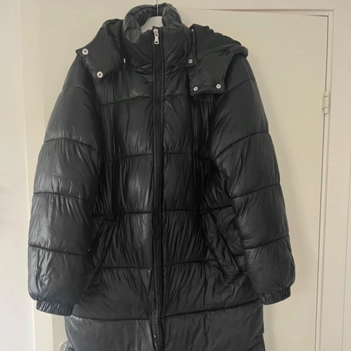 Svart glansig lång jacka