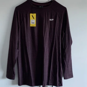 Mörklila långärmad tröja från MP - Säljer en mörklila långärmad tröja från MP i nyskick. Perfekt för träning eller vardagsbruk. Tröjan är i storlek XS och har en enkel design med MP-loggan på bröstet. Materialet känns mjukt och bekvämt, idealiskt för höst och vår.  Helt ny  aldrig använd. Orginalförpackning följer med. 