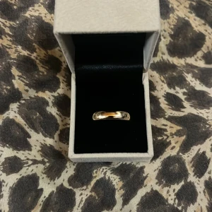 Elegant guldring i minimalistisk design - Säljer en stilren och elegant guldring i minimalistisk design. Ringen har en slät yta och en klassisk form som passar perfekt till både vardag och fest. 