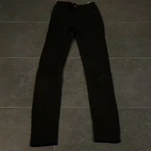 Svarta jeans från Vero Moda - Säljer ett par svarta jeans från Vero Moda i storlek XXS. De är i bra skick och har en klassisk skinny fit som passar perfekt till både vardag och fest. Jeansen är tillverkade i ett bekvämt denimtyg och har en stilren design utan extra detaljer.